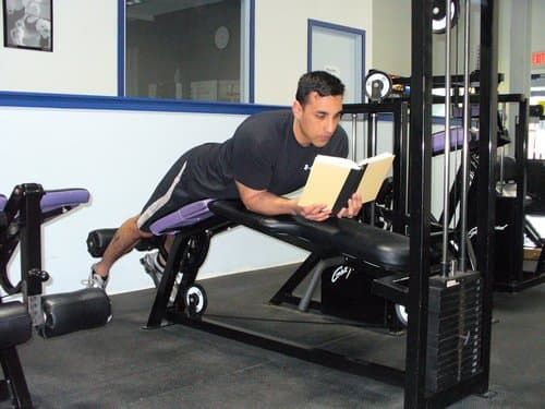 Мужчина читает книгу в спортзале фитнес-клуба